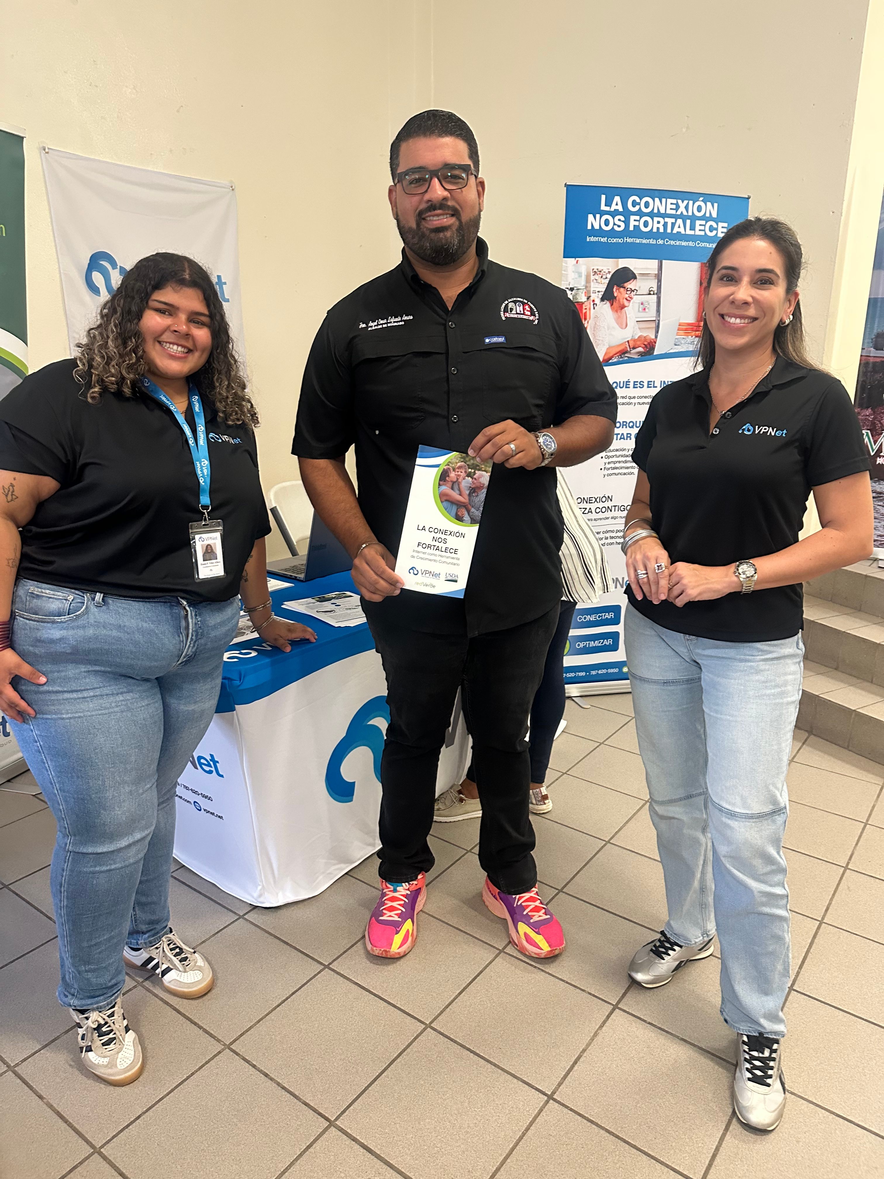 Alcalde junto al equipo de vpnet sosteniendo el folleto La conexión nos fortalece