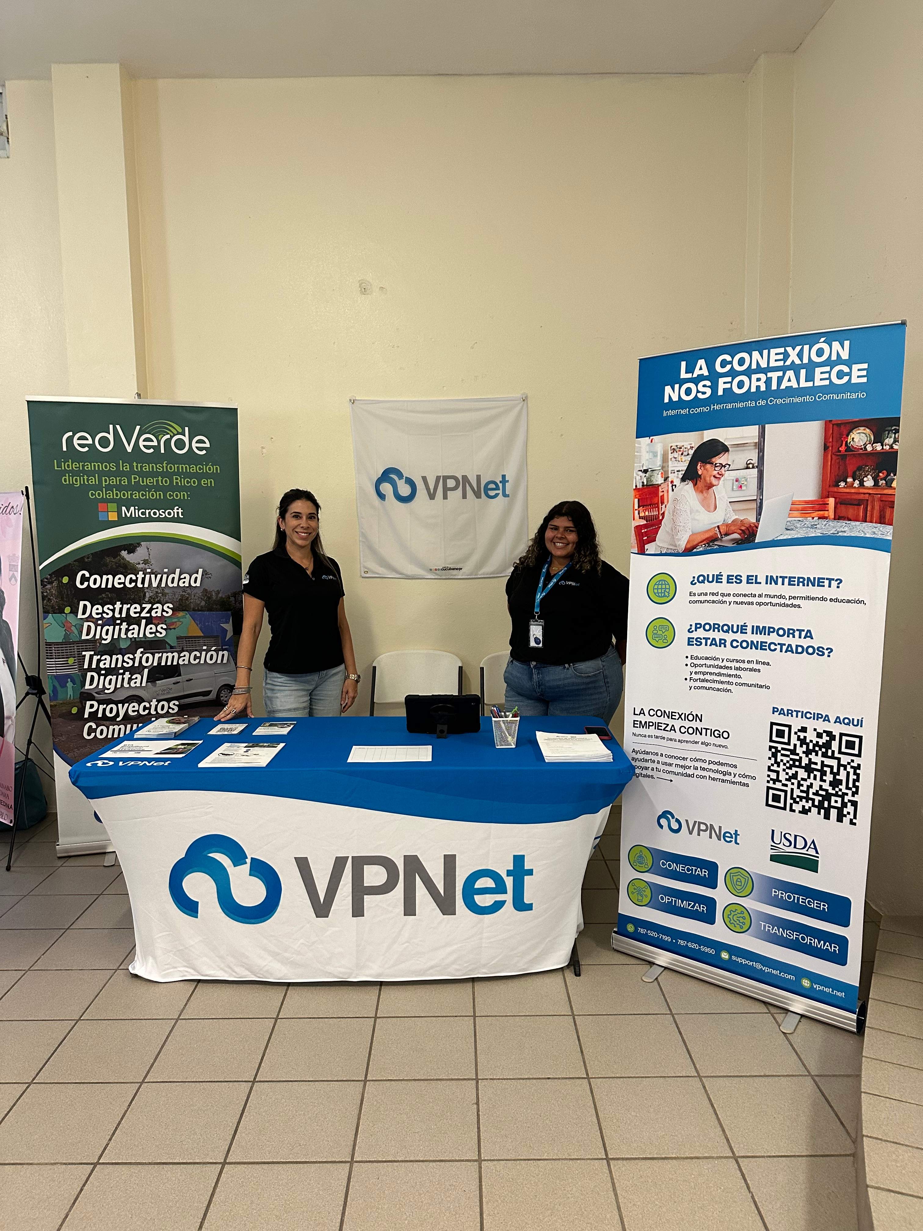 Equipo de vpnet en su mesa informativa junto a los banners de redVerde y La conexión nos fortalece