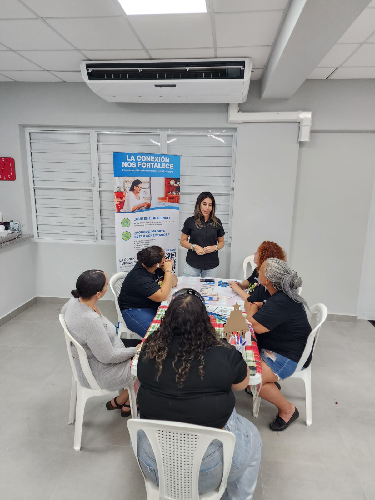 Taller comunitario con un grupo de residentes sentadas alrededor de una mesa